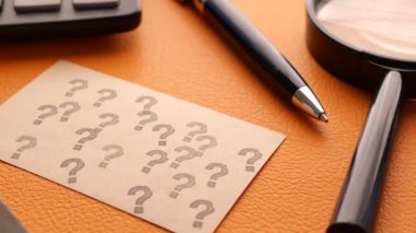 Ofis masasındaki kağıttaki soru işaretinin yüksek açılı görünümü.