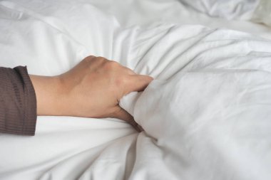 Beyaz çarşafları çeken kadınların eli...