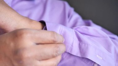 Adam gömleğini ilikliyor..