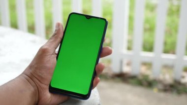 Açık havada akıllı telefon kullanan genç bir adamın dikiz görüntüsü .