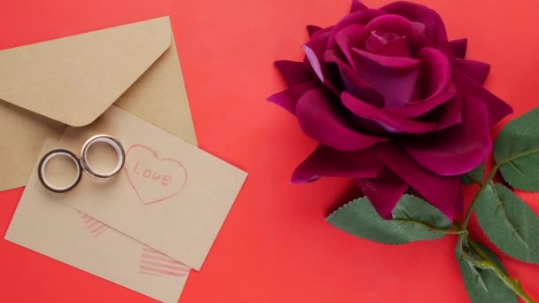 結婚指輪とギフトボックスと赤いバラの花 — ストック動画