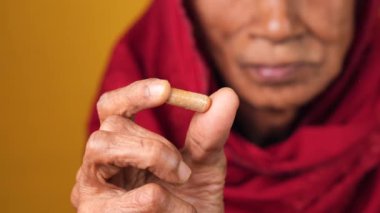  Yaşlı kadınların elinde bitkisel ilaç kapsülü var. .