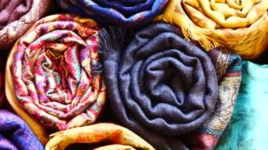 Renkli kumaşlar, yatak örtüleri ve farklı doğu desenli mendiller.