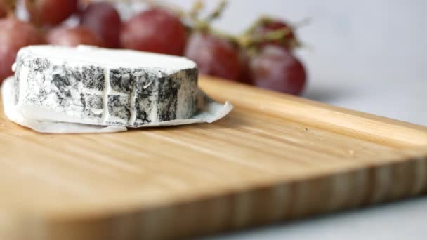 木制背景的新鲜山羊奶酪和葡萄果 — 图库视频影像