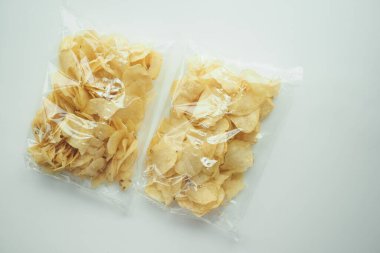 Patates cipslerinin beyazın üzerinde plastik bir pakette üst görünümü ,