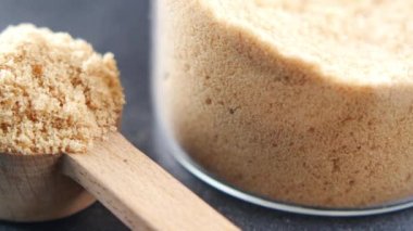 crystal brown sugar brown on a wooden spoon on table ,