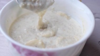 Yulaf, muz ve süt siyah arka planda bir kasede .