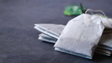 Çay poşetleri ve sarı renkli bardak masanın üstünde. .