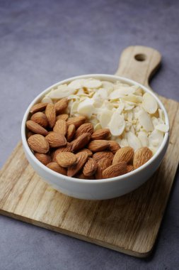 Badem fıstığının en üst görüntüsü ve masada bir kâse dilimle. .