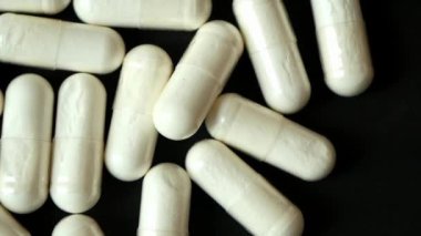 Bitkisel ilaç kapsülünün beyaza düşüşünün üst görüntüsü ,