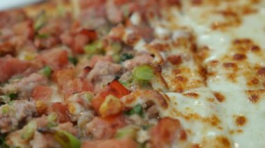 Tahta masadaki bir tabakta peynirli pizza.