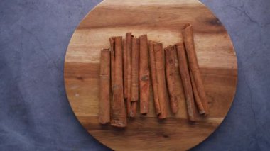 Dönen Tarçın çubukları masadaki doğrama tahtasında .