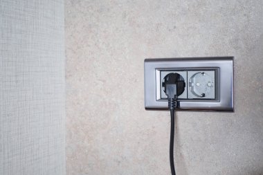  white color power cord cable plugged into wall .