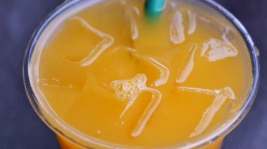 Plastik bardakta buzlu portakal suyu. .