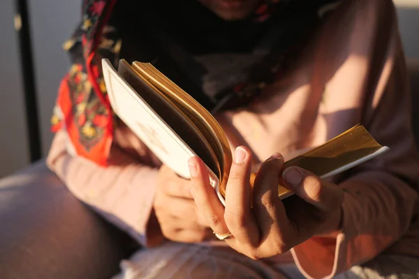 Muslim womens hand reading quran at night .