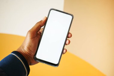 Genç adam beyaz ekranlı akıllı telefon kullanıyor. .