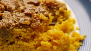 boiled yellow rice with meats on a plate .