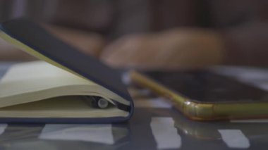 Not defteri, kalem ve akıllı telefon masada. .
