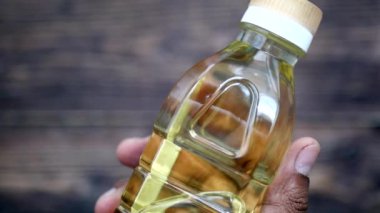 Bir şişe zeytinyağını tutan el. .