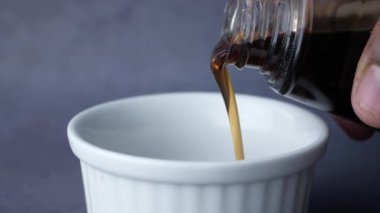 Bir şişe akçaağaç şurubu dökülüyor. .