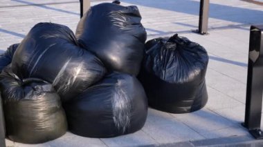 Siyah çöp torbaları parka yığılmış. .