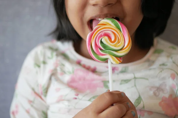 Child Licking Colorful Candy Stick — Stockfoto