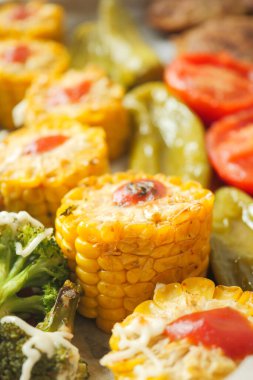 Beyaz kabartma kağıdında otlarla pişirilmiş mısır kulakları..