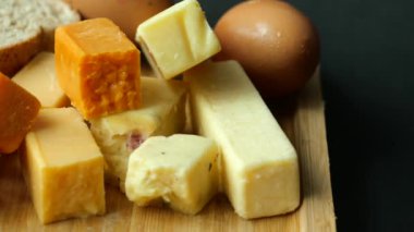 Cheese cubes green, yellow and red color on chopping board .