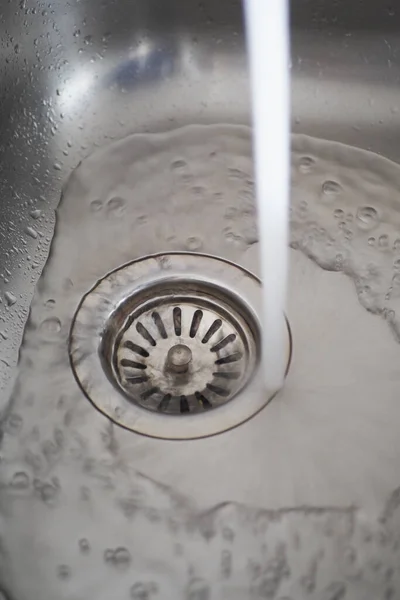 stock image water pouring from a faucet tap slow motion .