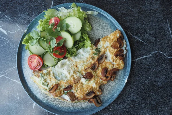 平卵オムレツとテーブルの上に新鮮なサラダ — ストック写真