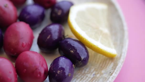 Schwarze Und Rote Oliven Mit Zitrone Auf Einem Teller — Stockvideo