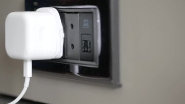  white color power cord cable plugged into wall .