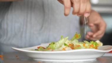 Yakın plan kadınlar salatada yarım dilim limon sıkıyor. .