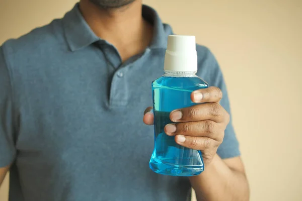 stock image  hand hold a mouthwash liquid container .