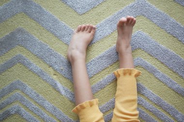 Yumuşak halıdaki kuru çocuk ayaklarının üst görünümü .