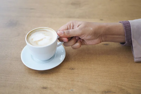 stock image women holding a coffee cup on table ,