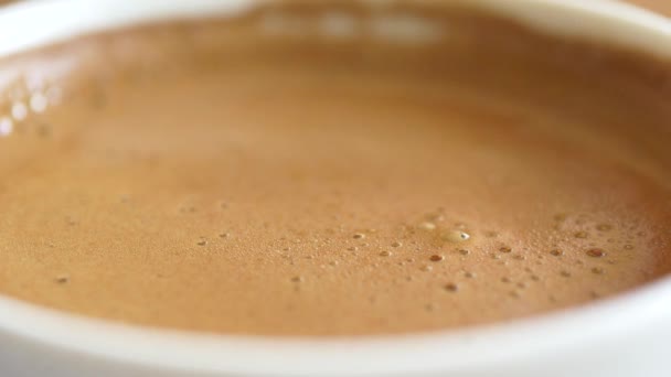 白い背景に泡のあるホットコーヒーの上からの眺め — ストック動画