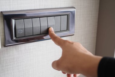 Işık düğmesini açan bir parmak