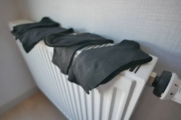 加热散热器上的黑色袜子烘干 — 图库照片
