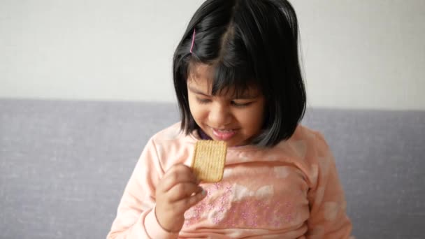 Ένα Χαρούμενο Παιδί Τρώει Μπισκότα Καθισμένο Στον Καναπέ — Αρχείο Βίντεο