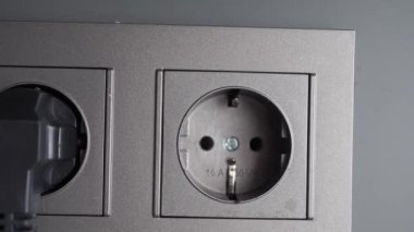  white color power cord cable plugged into wall .