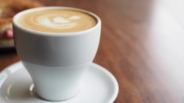 カフェの上に花の形がデザインされた後期コーヒーのカップ — ストック動画