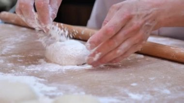 Dişi eller ekmek ve ekmek pişirmek için hamur parçaları oluşturur.