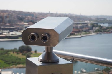 Şehir binalarını gözetleyen madeni paralı dürbünler.