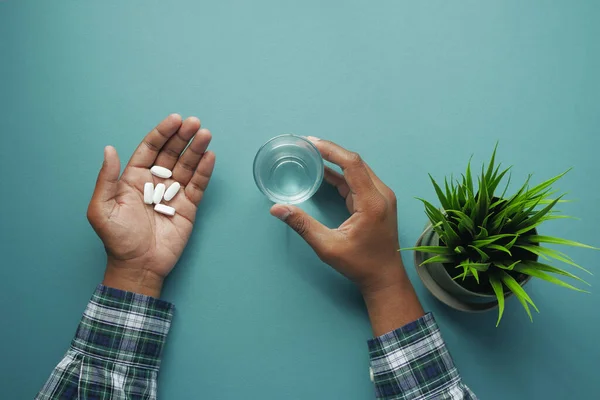 taking medicine concept. Close up of man hand holding pills with copy space .