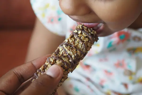 child eating protein bar close up .