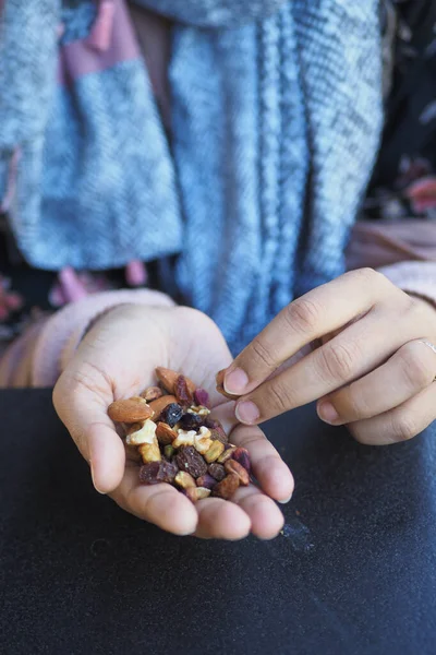 women hand pick mixed nuts .