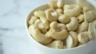 Siyah arka planda küçük bir kasede kaju fıstığı. ,