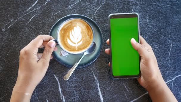 Κρατώντας Ένα Cpu Του Καφέ Και Χρησιμοποιώντας Έξυπνο Τηλέφωνο Πράσινη — Αρχείο Βίντεο