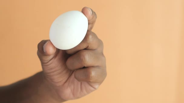 Primo Piano Degli Uomini Mano Tenendo Uovo Contro Sfondo Colore — Video Stock